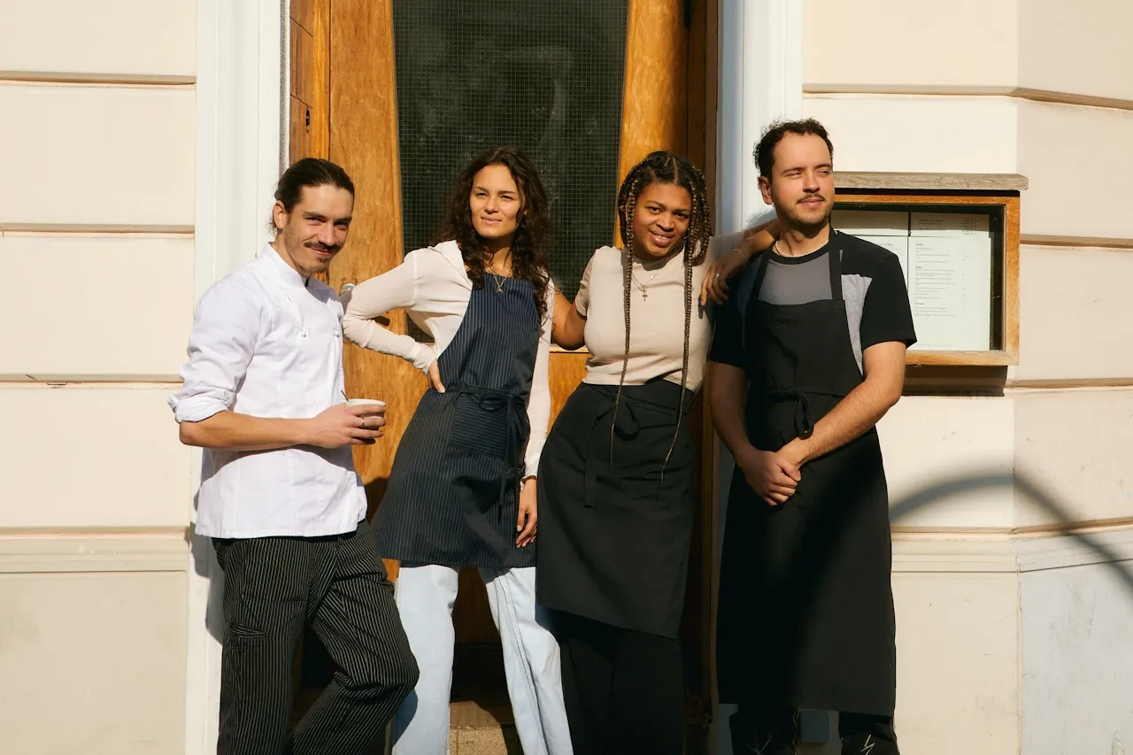 Four restaurant staff members standing outside their restaurant
